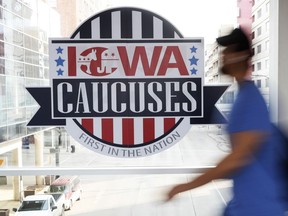 FILE - A pedestrian walks past a sign for the Iowa Caucuses on a downtown skywalk, in Des Moines, Iowa, on Feb. 4, 2020. Iowa Republicans have scheduled the party's presidential nominating caucuses for Jan. 15, 2024, putting the first votes of the next election a little more than six months away.