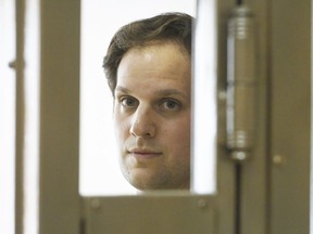 FILE - Wall Street Journal reporter Evan Gershkovich stands in a glass cage in a courtroom at the Moscow City Court in Moscow, Russia, June 22, 2023.