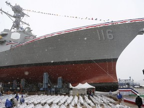 FILE - Snow falls on the future USS Thomas Hudner, a U.S. Navy destroyer named after Korean War veteran Thomas Hudner, during christening ceremony at Bath Iron Works in Bath, Maine, April 1, 2017. The U.S. is sending additional fighter jets and a warship to the Strait of Hormuz and the Gulf of Oman to increase security in the wake of Iranian attempts to seize commercial ships there. The Pentagon said Monday that the USS Thomas Hudner, a destroyer, and a number of F-35 fighter jets will be heading to the area. The Hudner had been in the Red Sea.