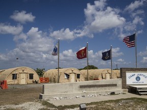 FILE - In this photo reviewed by U.S. military officials, flags fly in front of the tents of Camp Justice in Guantanamo Bay Naval Base, Cuba, on April 18, 2019. For the first time since the facility in Cuba opened in 2002, a U.S. president had allowed a United Nations independent investigator, Fionnuala Ní Aoláin, to visit.