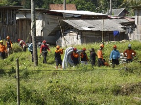 Members of the Indonesian National Search and Rescue Agency (BASARNAS) prepare to save miners who have been trapped at an illegal mining area in Banyumas, Central Java province, Indonesia, Thursday, July 27, 2023. Indonesian rescuers upped their efforts Thursday to save multiple miners who have been trapped in a pit at an illegal mining area since late Tuesday evening.