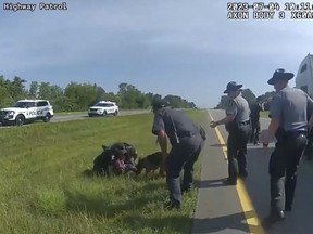This image taken from police body cam video shows a police dog attacking Jadarrius Rose, 23, of Memphis, Tennessee on Tuesday, July 4, 2023, in Circleville, Ohio. An investigation has been launched into why an Ohio officer allowed his police dog to attack a truck driver who was surrendering with his hands raised, despite State Highway Patrol troopers urging the officer to hold the dog back. (Ohio State Highway Patrol via AP)