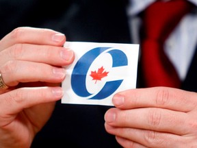 A man holds up a Conservative logo during the draws to determine various details of the upcoming two televised federal election debates took place in Ottawa, April 6 , 2011. Canadians will go to the polls May 2.