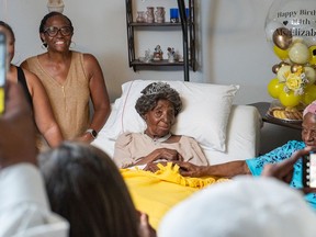 Elizabeth Francis, center, with family members and friends on her 114th birthday in Houston on July 25. Her daughter, Dorothy Williams, 94, is holding her hand, and granddaughter Ethel Harrison is at left. MUST CREDIT: Emmanuel Rodriguez
