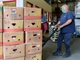 Workers load flats of food from donations and grocery stores into the Ottawa Food Bank's warehouse near St. Laurent Blvd.