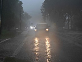 A police car drives through heavy rains in Archer, Fla., after Hurricane Idalia made landfall.