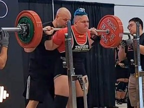 Trans powerlifter Anne Andres lifting weights during a competition.