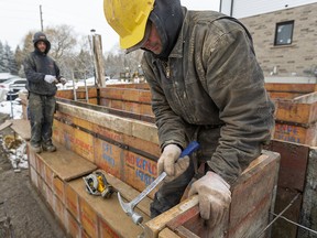 A construction worker works on the foundation for a new house in London, Ont.