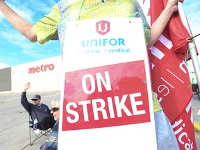 Metro grocery store workers picket outside a supermarket at Danforth and Victoria Park avenues in East Toronto on Aug. 1.