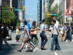 A group of people cross an intersection in downtown Vancouver.