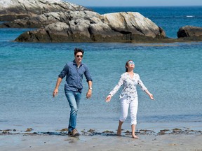 Prime Minister Justin Trudeau and his wife Sophie Gregoire Trudeau walk on the beach at Kejimkujik Seaside National and Historic Park in Port Joli, N.S., on Friday, July 21, 2017
