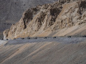 FILE- Indian army vehicles move in a convoy in the cold desert region of Ladakh, India, Sept. 18, 2022. Chinese and Indian military commanders have pledged to "maintain the peace and tranquility" along their disputed border in an apparent effort to stabilize the situation following a rise in tensions. China's Defense Ministry issued a joint press release on social media saying the 19th round of commander-level talks between the sides had produced a "positive, constructive and in-depth discussion" centered on resolving issues related to the Line of Actual Control in the border's western sector.