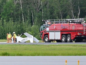 Firefighters look over a Cessna 152 aircraft after it crashed on landing at the Jean-Lesage Airport Aug. 1, 2023 in Quebec City.