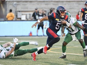 Montreal Alouettes quarterback Caleb Evans (5) breaks away from the Saskatchewan Roughriders defence during first half CFL football action in Montreal, Friday, August 11, 2023.