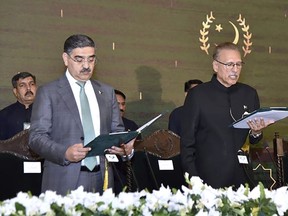 In this photo released by Pakistan's President Office, President Arif Alvi, right, administrates oath from Anwaar-ul-Haq Kakar as caretaker Prime Minister during a ceremony, in Islamabad, Pakistan, Monday, Aug. 14, 2023. Kakar was sworn in as the country's prime minister to head a caretaker national government that will oversee parliamentary elections amid one of the worst economic crises the Islamic nation has faced, officials said. (Pakistan President Office vis AP)