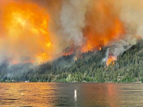 The Downton Lake wildfire near Gold Bridge B.C., burns toward the north shore of Gun Lake in this Tuesday, August 1, 2023 handout photo.
