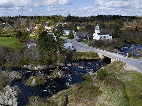 FILE - The Pleasant River flows through Columbia Falls, Maine, April 27, 2023. Plans to build the world's tallest flagpole are being delayed again. The town of Columbia Falls is extending its moratorium on big developments for another six months to allow more time to complete needed rules and regulations.
