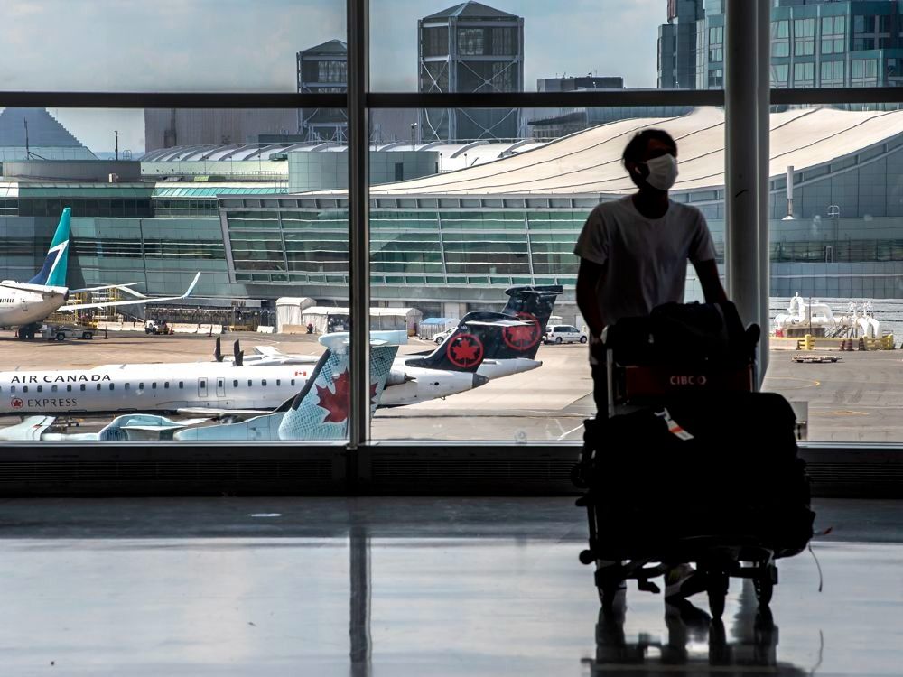 A traveller walking with his luggage at Toronto Pearson International Airport. 