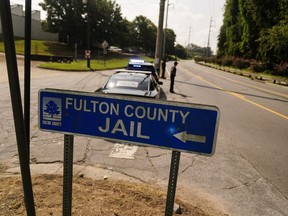 FILE - A Fulton County Jail signs points to where the jail is located, Thursday, Aug. 24, 2023, in Atlanta. Authorities say a 34-year-old man who was being held at the problem-plagued Fulton County Jail died after being taken to a hospital. He was the fourth person to die in county custody in the span of a month.