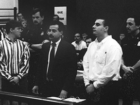 FILE - James Pugh, left, looks back at his family while his co-defendant, Brian Scott Lorenzo, right, and Lorenzo's attorney, Joseph J. Terranova, listen to the judge during their sentencing on May 6, 1994. A judge has ordered new trials for the two men convicted of murdering a woman in 1993 inside her home near Buffalo, N.Y., but who have always maintained their innocence. (The Buffalo News via AP)