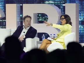 FILE - Elon Musk, left, speaks with Linda Yaccarino, April 18, 2023, in Miami Beach, Fla. The new CEO of the company formerly known as Twitter says she's spent much of the past eight weeks trying to get big brands back to advertising on the social media platform that's been in upheaval since it was bought last year by Musk. X Corp. CEO Linda Yaccarino said Thursday, Aug. 10 on CNBC that she been focused on talking with brands like Coca Cola, Visa and State Farm.