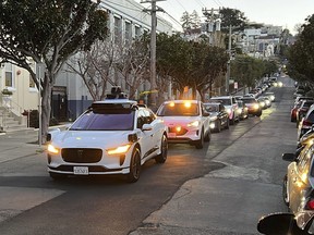 FILE - A Waymo driverless taxi stops on a street in San Francisco for several minutes because the back door was not completely shut, while traffic backs up behind it, on Feb. 15, 2023. California regulators are poised to decide whether two rival robotaxi services can provide around-the-clock rides throughout San Francisco, despite escalating fears about recurring incidents that have cause the driverless vehicles to block traffic or imperil public safety.