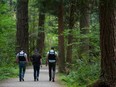 Police walk through Central Park in Burnaby on July 21, 2017.
