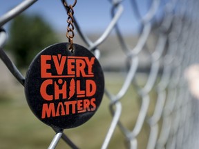 A key chain dangles from a fence as part of a memorial outside the former Kamloops Indian Residential School.