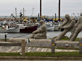 A sculpture shows fishermen pulling on a line in front of the marina, Monday, August 6, 2012, in L'Étang du Nord on the Îles-de-la-Madeleine.