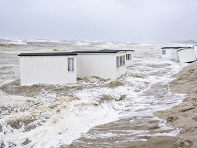 Picnic cabins get flooded in the water of the North Sea in the strong winds in Loekken, Denmark, Tuesday, Aug. 8, 2023.