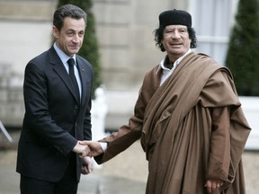 FILE - French President Nicolas Sarkozy, left, greets Libyan leader Col. Moammar Gadhafi upon his arrival at the Elysee Palace, in Paris Dec. 10, 2007. French investigative magistrates on Friday, Aug. 25, 2023, ordered former president Nicolas Sarkozy and 12 others to go on trial on charges that his 2007 presidential campaign received millions in illegal financing from the government of late Libyan leader Moammar Gadhafi.