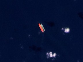 FILE - In this satellite photo provided by Planet Labs PBC, vessels identified as the Virgo, left, and the Suez Rajan, by the advocacy group United Against Nuclear Iran, are seen in the South China Sea on Feb. 13, 2022. An American-owned oil tanker long suspected of carrying sanctioned Iranian crude oil began offloading its cargo near Texas late Saturday, Aug. 19, 2023, tracking data showed, even as Tehran has threatened to target shipping in the Persian Gulf over it.