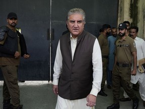 FILE - Shah Mahmood Qureshi, center, a top leader of Pakistan's former Prime Minister Imran Khan's "Pakistan Tehreek-e-Insaf" party, leaves after appearing in court in his case, in Lahore, Pakistan, on Aug. 8, 2023. Pakistan's top investigation agency has arrested an opposition leader, who is a close aide of convicted former Prime Minister Imran Khan, for exposing official secrets and harming state interests, according to case documents revealed Sunday, Aug. 20.