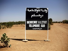 FILE - A sign on the northern road exiting in Gao, Northern Mali, reads "welcome to the islamic state of Gao on Jan. 30, 2013. Islamic State extremists have almost doubled the territory they control in Mali in less a year, and their al-Qaida-linked rivals are also capitalizing on the deadlock and perceived weakness of armed groups that signed a 2015 peace agreement, United Nations experts said in a new report.