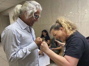 Phillip Picone, left, and Shere Dore fist bump after Picone is found not guilty, Friday, July 28, 2023, for breaking a law against feeding homeless people outside a public library in Houston, concluding the first trial to be held after dozens of tickets were issued against volunteers for the group Food Not Bombs.