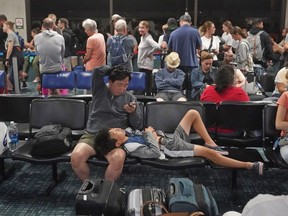 People gather at the Kahului Airport while waiting for flights Wednesday, Aug. 9, 2023, in Kahului, Hawaii. Several thousand Hawaii residents raced to escape homes on Maui as the Lahaina fire swept across the island, killing multiple people and burning parts of a centuries-old town.