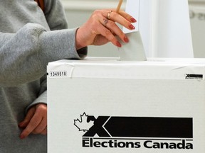 A ballot is placed in a ballot box during the 2021 federal election.