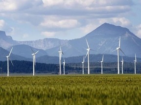 Alberta wind turbines with mountains in the background.