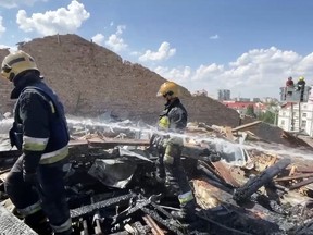 In this photo taken from video provided by the Ukrainian Emergency Service, firefighters work on the roof of the Taras Shevchenko Chernihiv Regional Academic Music and Drama Theatre damaged by Russian attack in Chernihiv, Ukraine, Saturday, Aug. 19, 2023. (Ukrainian Emergency Service via AP)