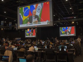 Members of the media watch Russia's President Vladimir Putin address via videolink the 2023 BRICS Summit in Johannesburg, South Africa, Wednesday, Aug. 23, 2023.