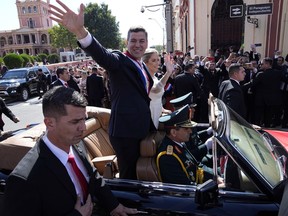 Paraguay's newly sworn-in President Santiago Pena and wife Leticia Ocampos wave from a car taking them to the Cathedral on Pena's inauguration day in Asuncion, Paraguay, Tuesday, Aug. 15, 2023.