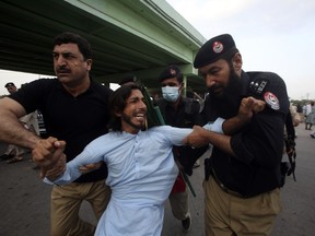 Police officers detain a supporter of Pakistan's former Prime Minister Imran Khan, in Peshawar, Pakistan, Saturday, Aug. 5, 2023. Pakistani police on Saturday arrested Khan at his home in the eastern city of Lahore after a court convicted him in an asset concealment case and handed him down a three-year prison sentence.