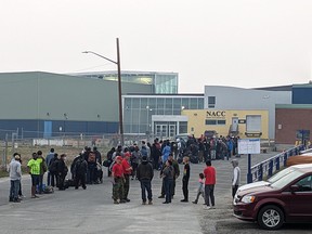 People without vehicles line up to register for an evacuation flight.
