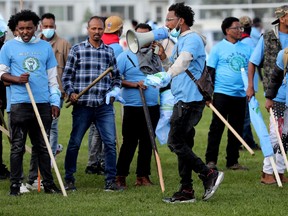 Anti-Eritrean government protestors hold large sticks in an Edmonton park.