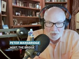 Peter Mansbridge performing a video interview in an office wearing headphones and talking into a microphone