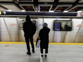 People wait on the platform to enter a subway train in downtown Toronto.