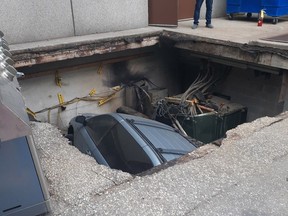 A section of asphalt collapsed on a hydro vault under a parked vehicle in a downtown Windsor alley on Tuesday, Sept. 19, 2023.