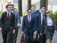 A group of U.S. Department of Justice lawyers walking outside a courthouse.