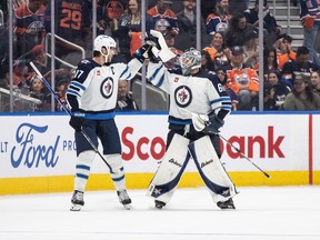 Winnipeg Jets' Adam Lowry (17) and goalie Collin Delia (60) celebrate their win against the Edmonton Oilers during shootout NHL preseason action in Edmonton on Sunday September 24, 2023.THE CANADIAN PRESS/Jason Franson