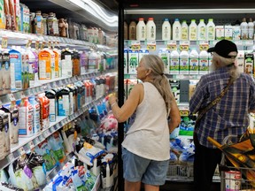 A man and woman shopping at a grocery store.